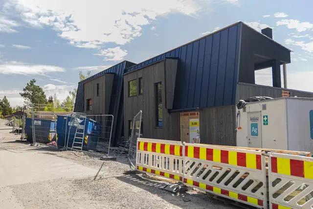 Den ferdige tomannsboligen i mørk kledning.