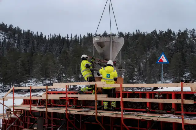 Betong heises inn til forskalingen ved dammen.