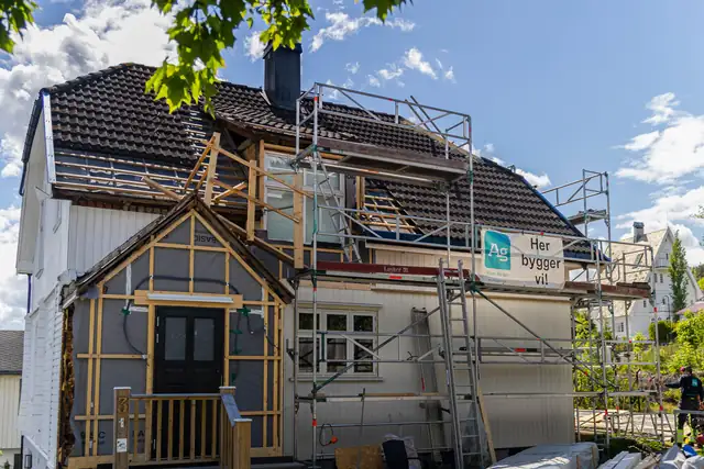 Huset med stillas og ny kledning på vei opp.