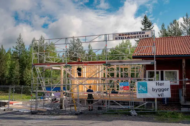 Påbygget under arbeid, med stillas mot det røde klubbhuset.