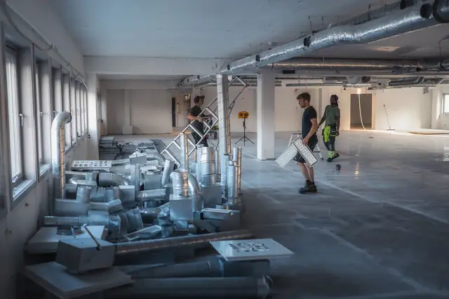 Det store lokalet før ombyggingen, med materialer på gulvet.