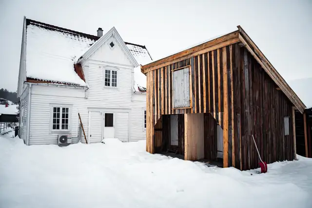 Det gjenoppførte uthuset mellom de hvite bolighusene.